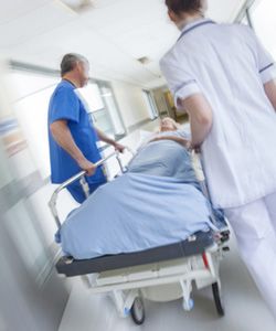 A gurney is rushed down a hospital corridor